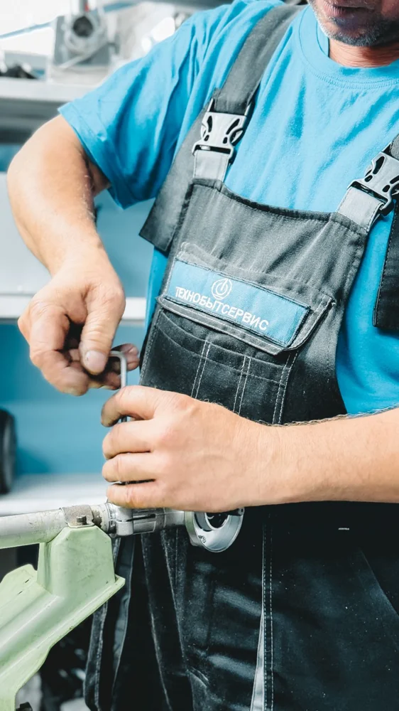 A plumber using hand tools to repair a pipe fitting.